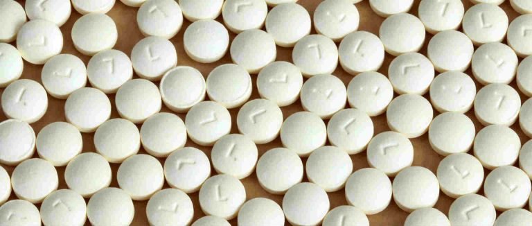 A bunch of white antihistamine tablets laying flat