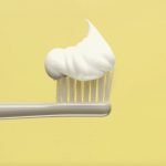 White toothpaste on a white toothbrush head
