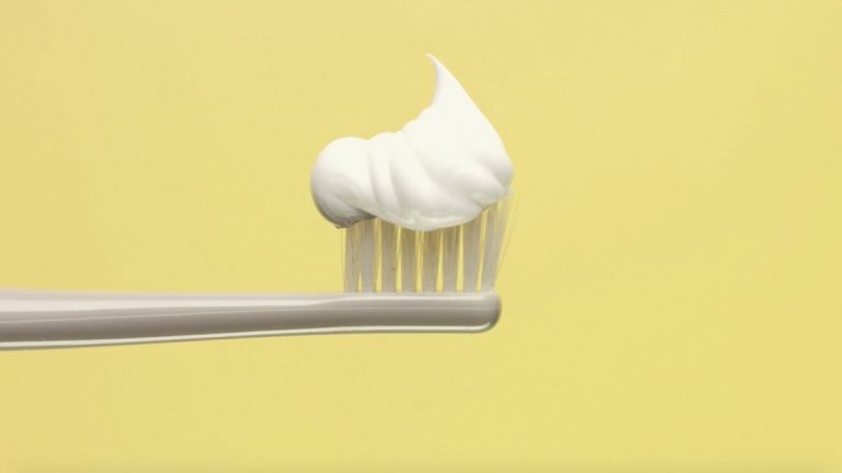 White toothpaste on a white toothbrush head