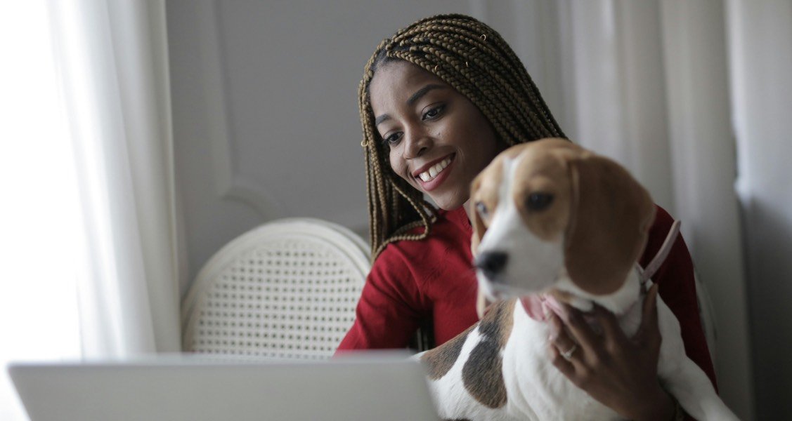 A woman and dog are looking at a computer screen