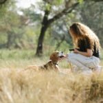 A woman is scratching a dog's chin outside