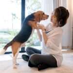 A female dog owner is holding a new puppy