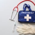 An image of a first aid kit, stethoscope, gloves and syringe